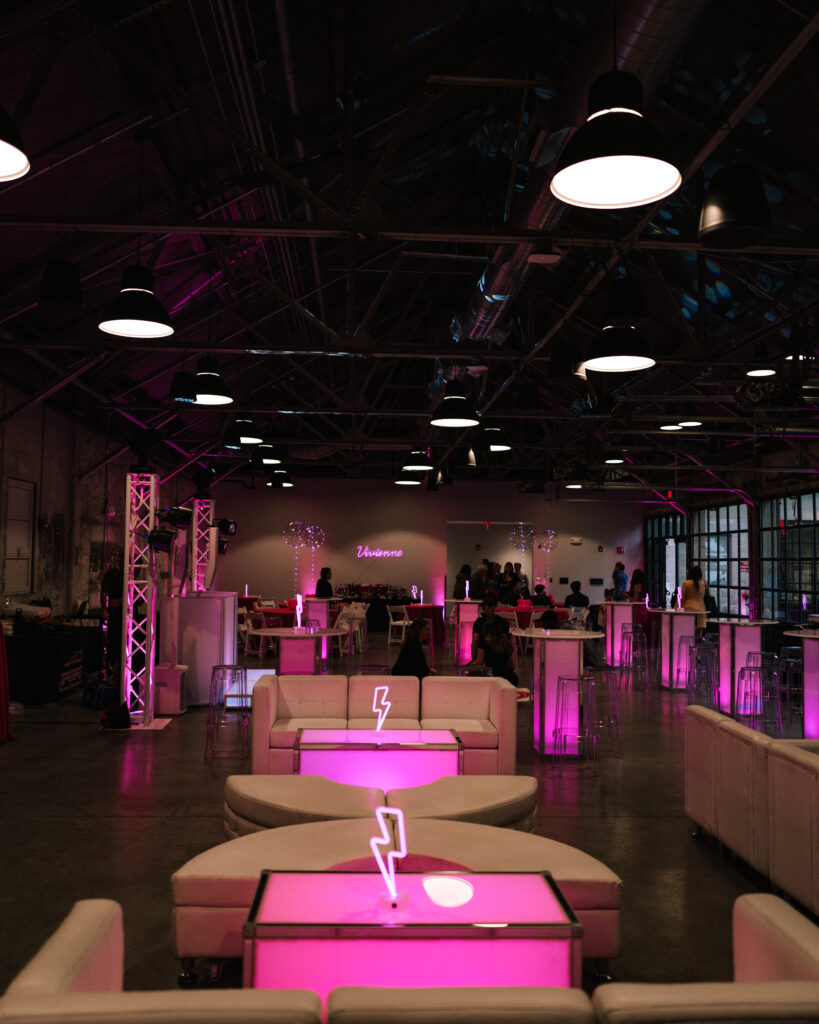 A mitzvah venue is decorated with pink neon