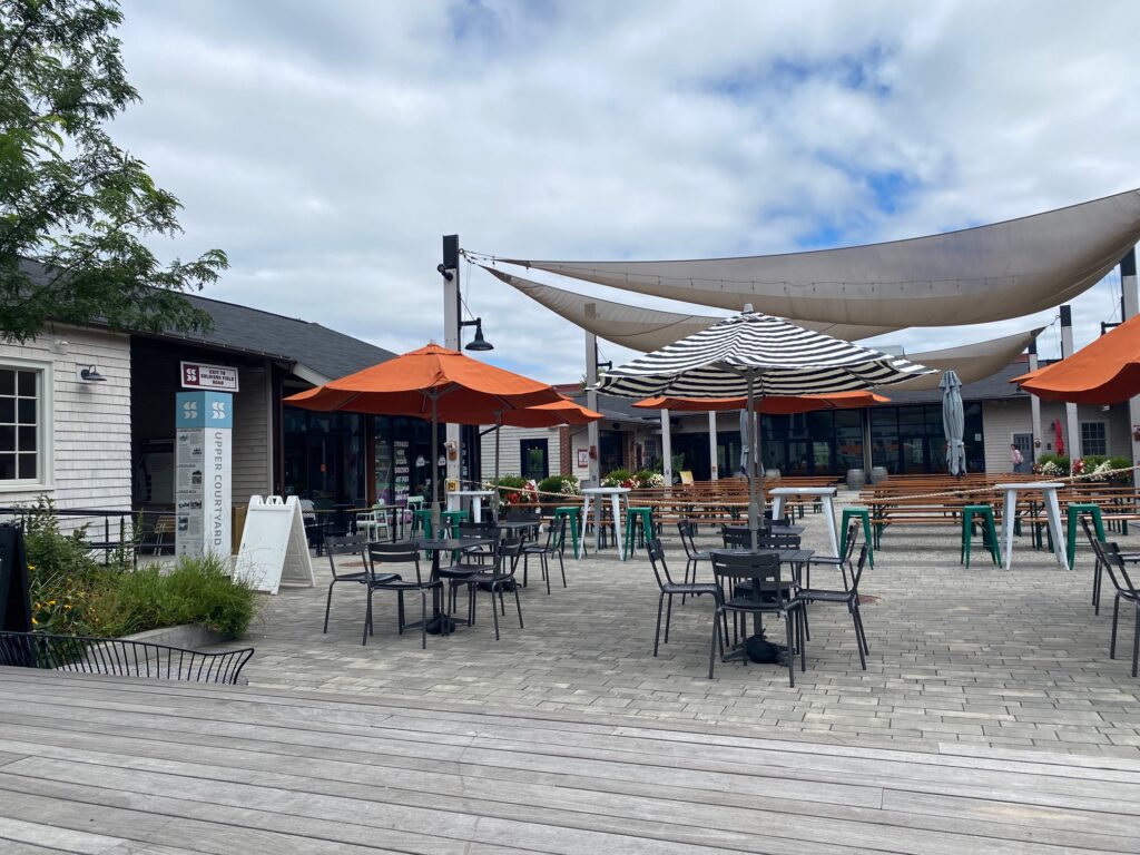 a patio area with umbrella tables and chairs at the Garage B event venue