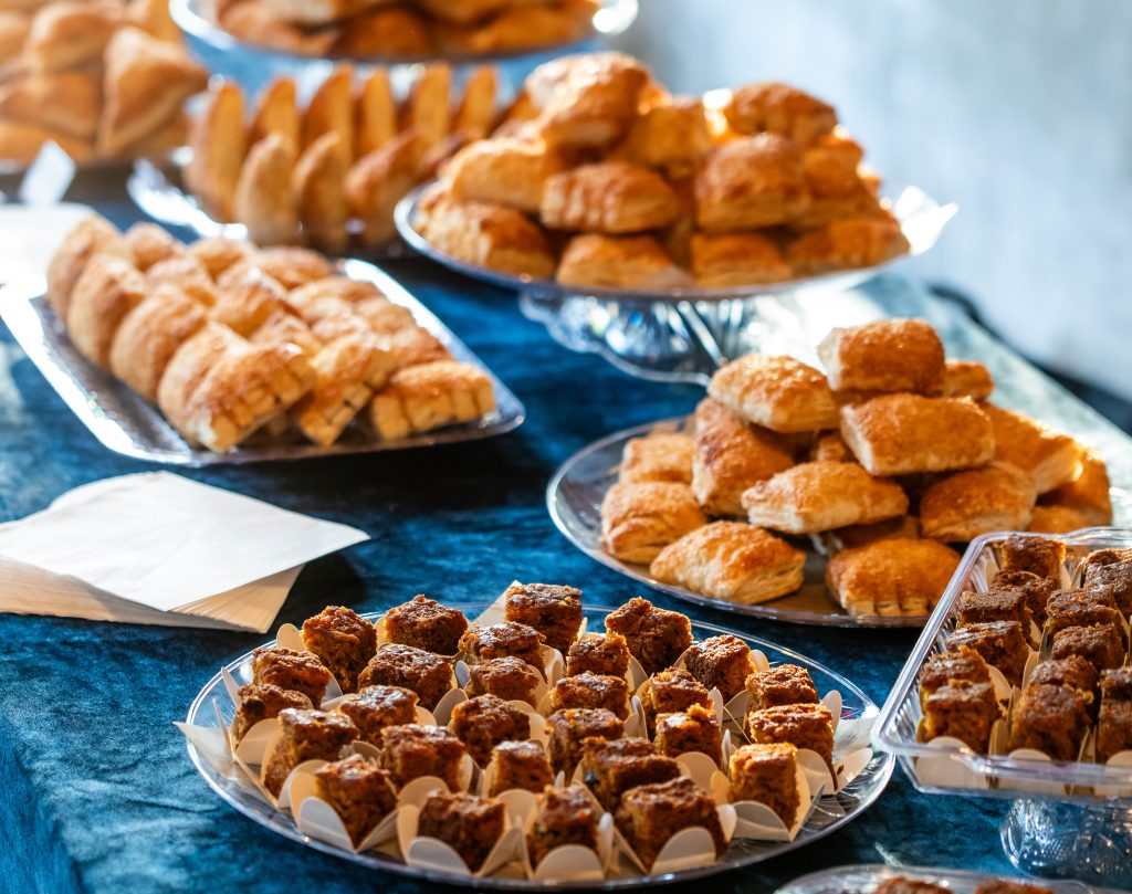 A table topped with an arrangement of different Colombian pastries organized on platters.