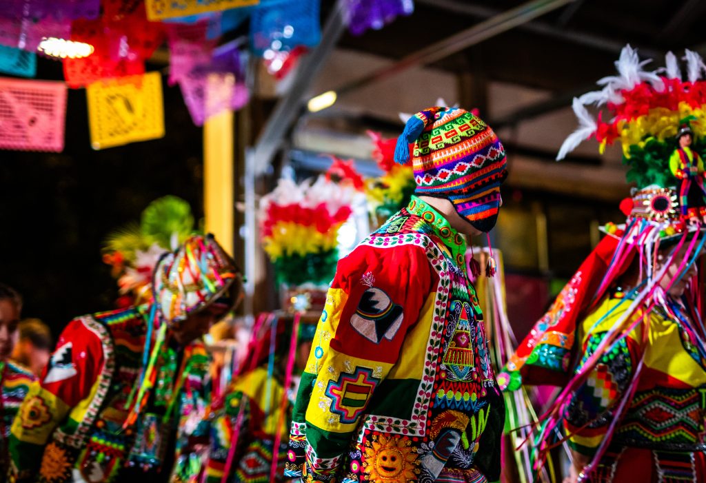 Tinku performers dance under banners of papel picado hung from steel rafters.